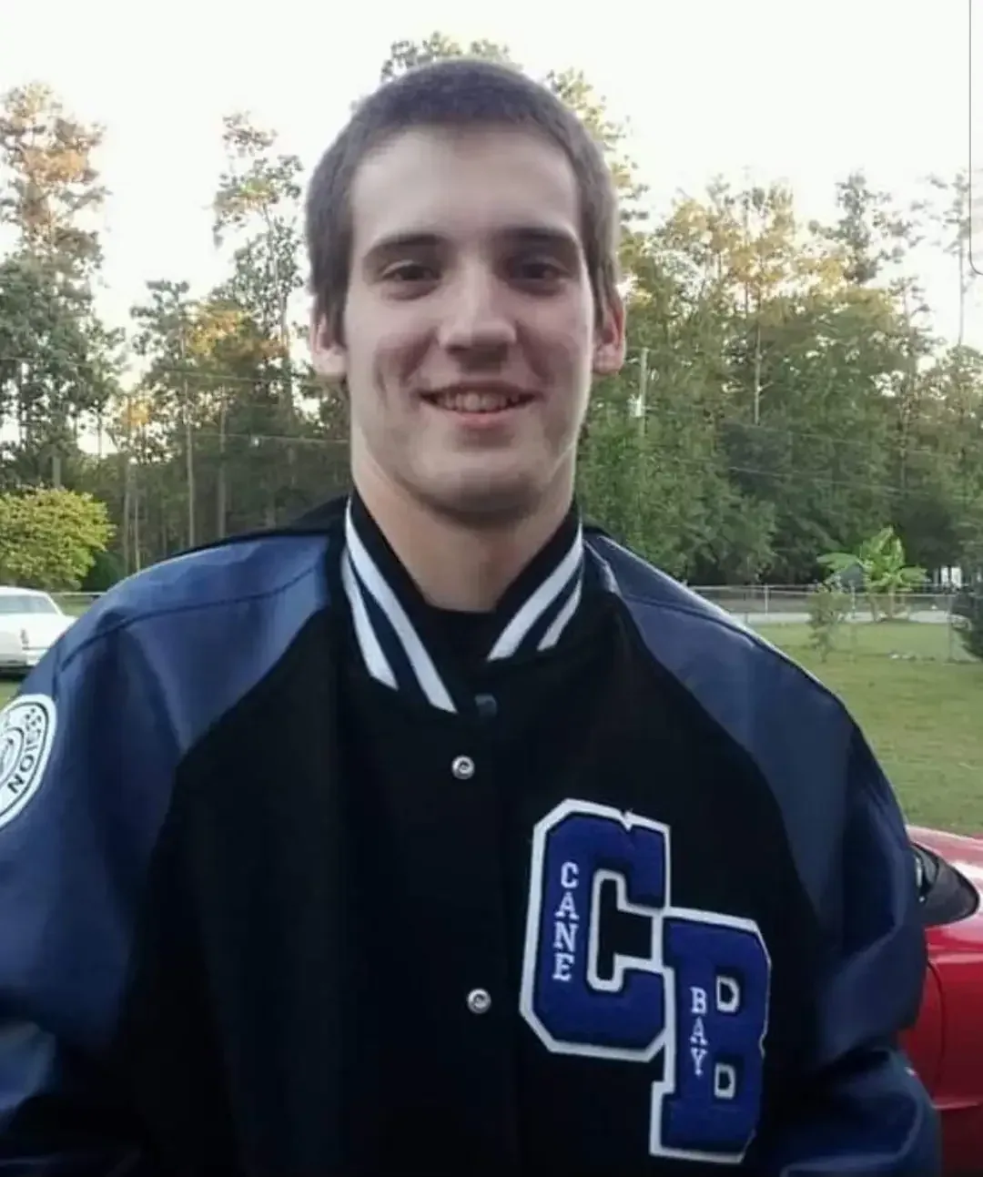 Justin Shelton smiling in his Cane Bay High letterman jacket
